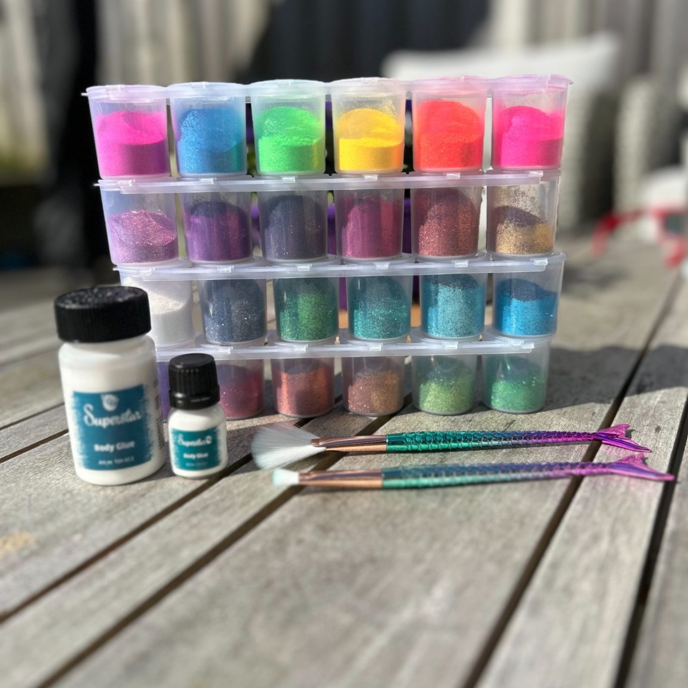 Kleurige verfpoeders en penselen op een houten tafel.